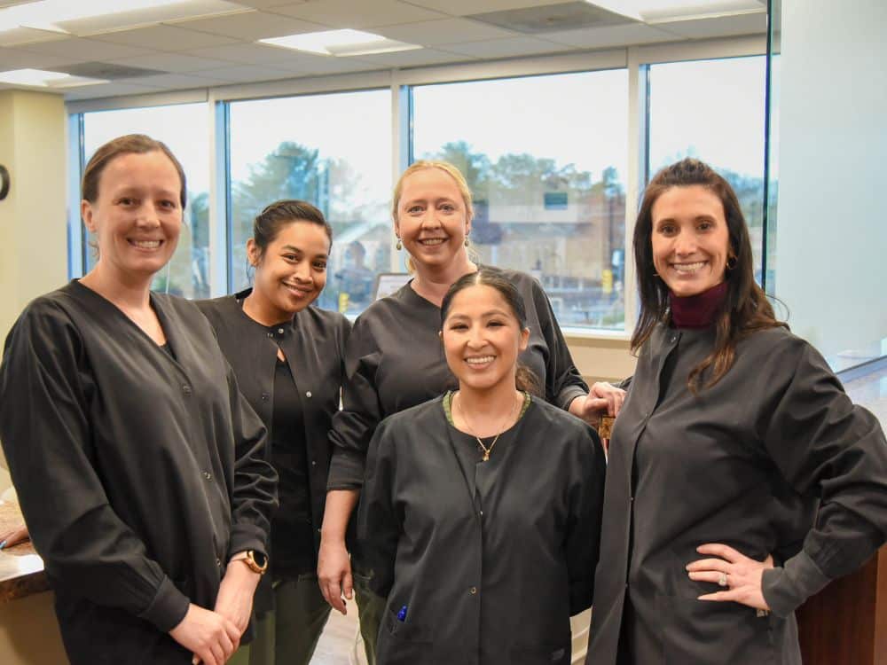 orthodontic team members inside dental office smiling